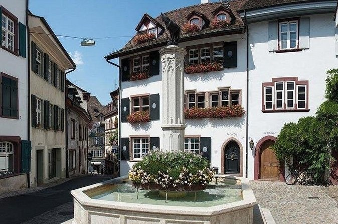 A flower-decked fountain in a square of shuttered Old Town houses