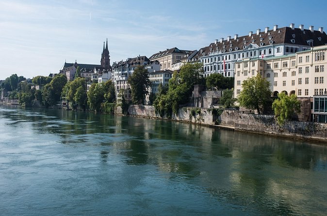 Old houses and trees along the Rhine bank, the Minster's spires beyond