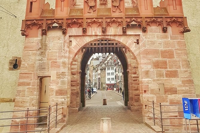 A red sandstone city gate, the street seen through its arch