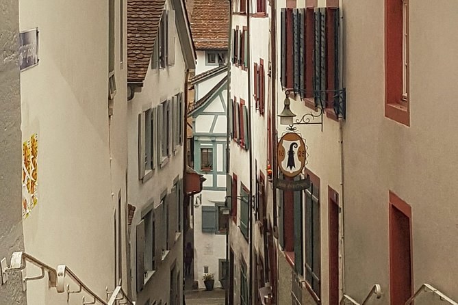 A steep Old Town lane of tall houses and hanging shop signs
