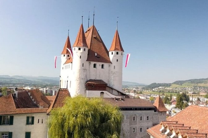 Thun Castle, white with four corner turrets, above the roofs of the town